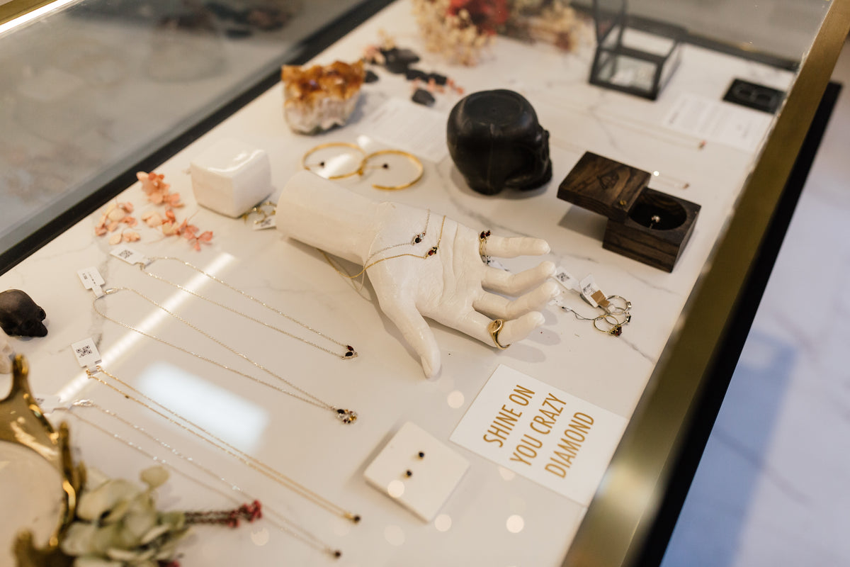 A Black Betty display table with a sculpted hand, necklaces and a Shine on you crazy diamond card