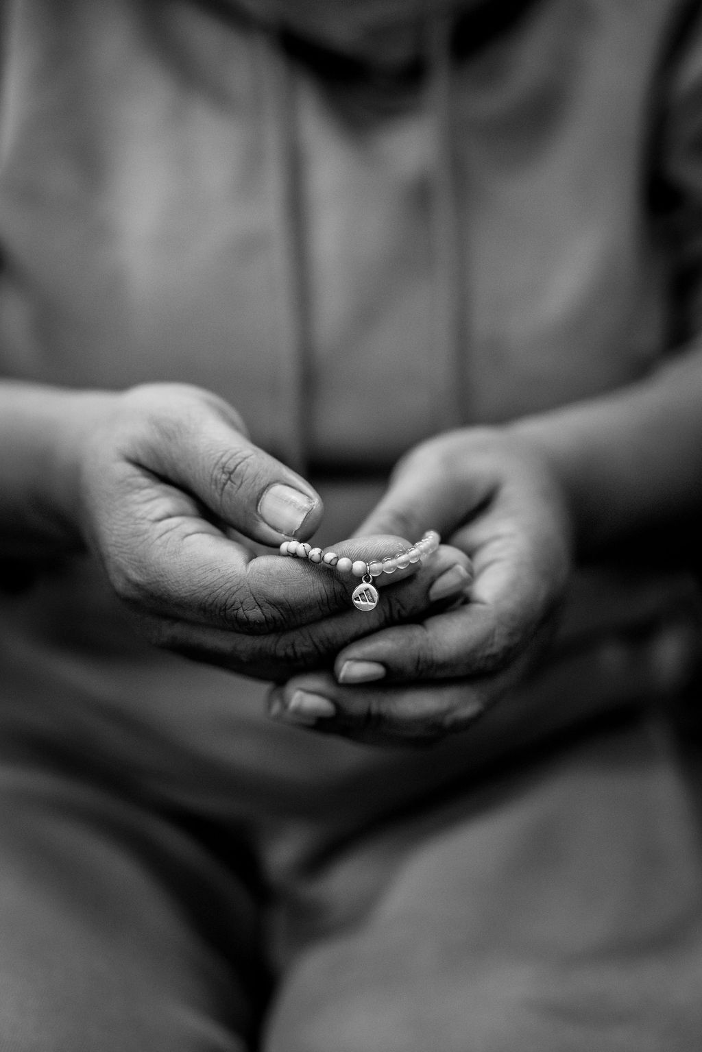 A beader's hands cradling a finished beaded bracelet